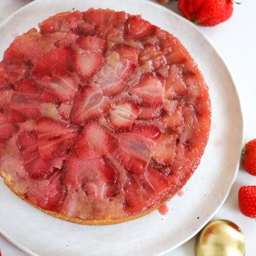 A strawberry upside down cake on a serving plate.