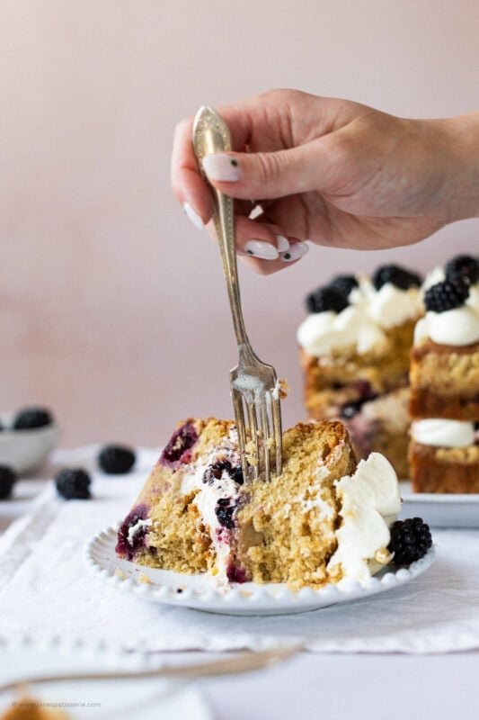 Fork into slice of two-layer apple blackberry cake