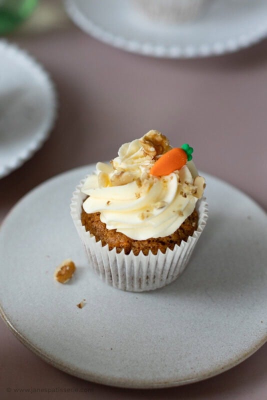 a carrot cake cupcake on a white plate