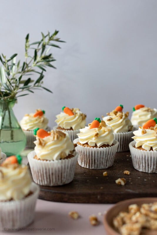 Scattered carrot cake cupcakes on a chopping board