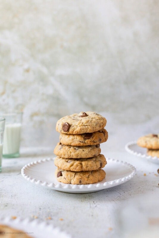 A stack of five chocolate oat cookies on a plate