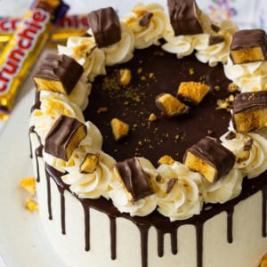 A Crunchie Drip Cake with Crunchies in the background