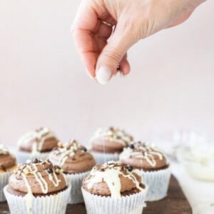 a hand putting sprinkles on a marble cupcake