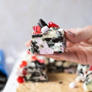 A hand holding a slice of Oreo Rocky Road