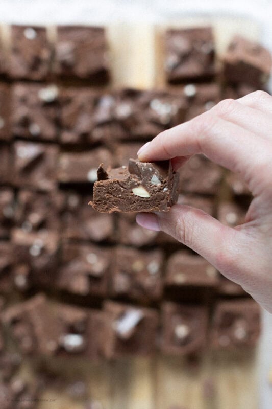 A hand holding a single Toberlone Fudge square