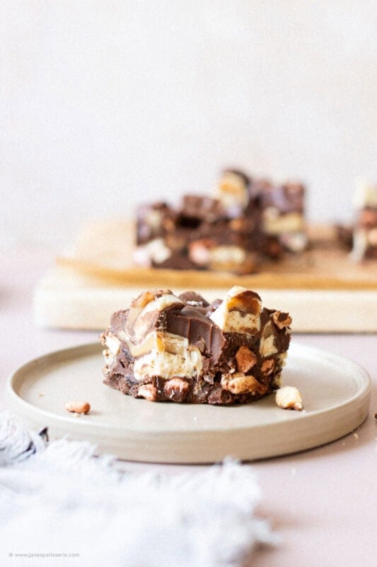 A bite missing from a square of Twix Rocky Road
