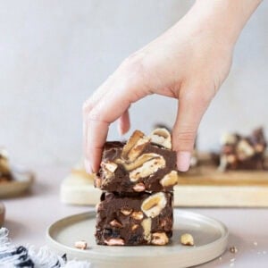 A hand taking a Rocky Road from a plate