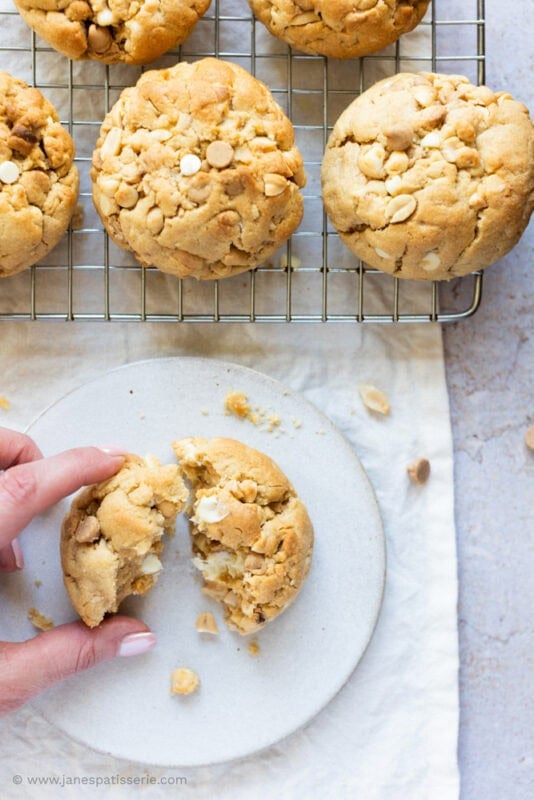 A hand reaching for a Peanut Butter NYC Cookie