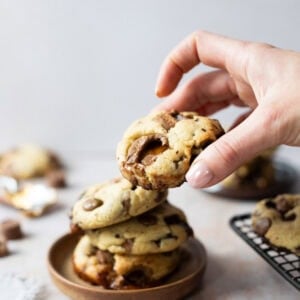 A hand taking a Rolo Cookie from a plate