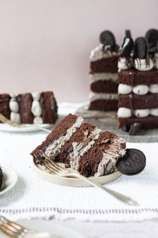 A slice of Oreo Cake on a plate with a fork