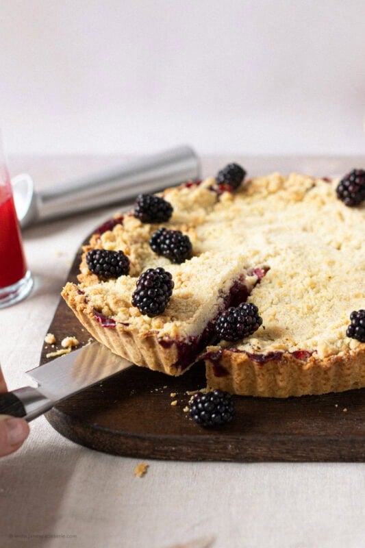 A slice being taken from a Apple and Blackberry Crumble Pie