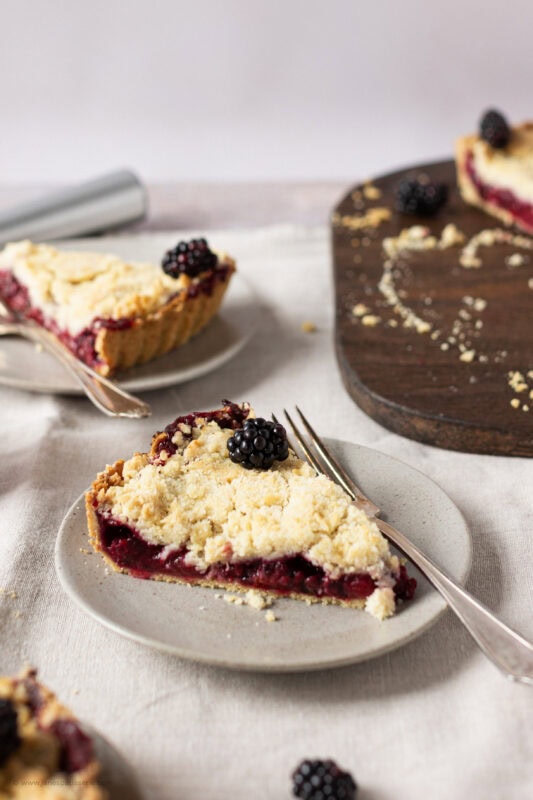A slice of Apple and Blackberry Crumble pie on a plate