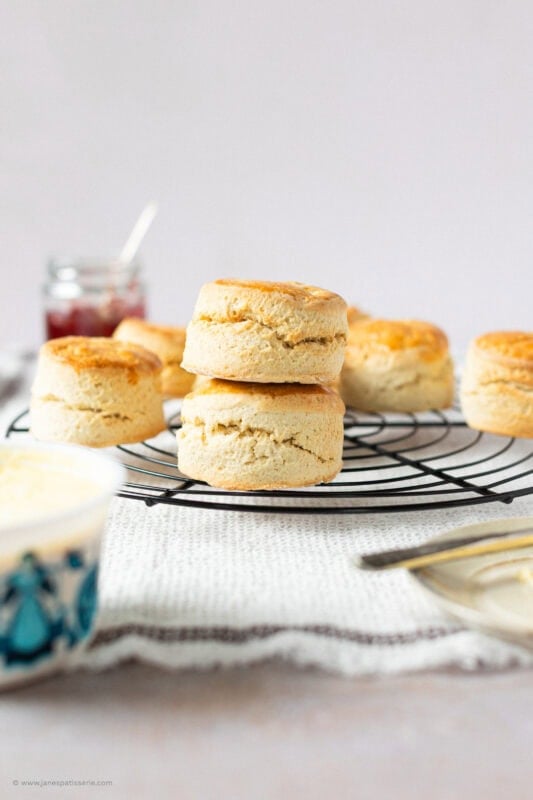 Two stacked classic buttery scones on a cooling rack