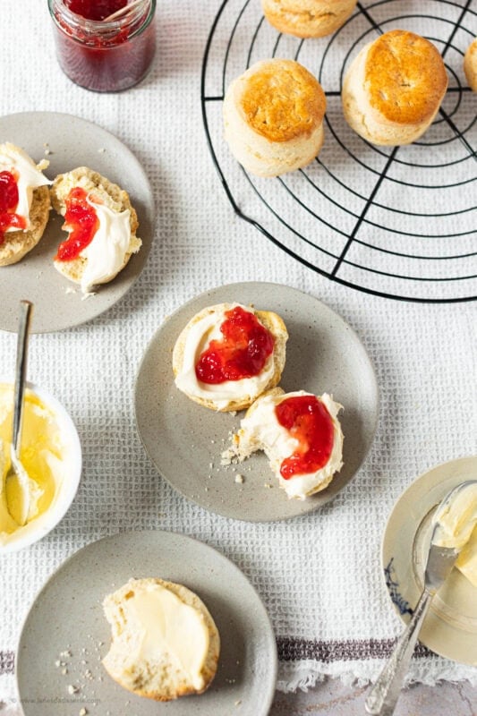 A plate of classic buttery scones next to a cooling rack