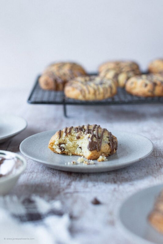 A bite taken from a Coconut Chocolate Rock in front of a cooling rack