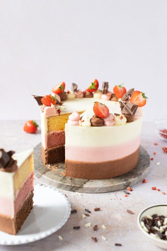 A slice completely removed from a Neapolitan Cake