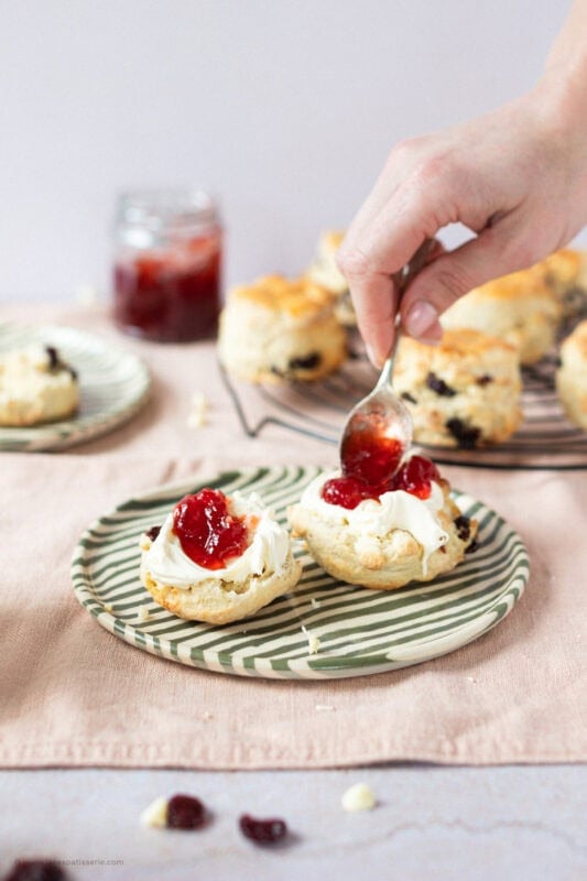Adding jam and clotted cream to White Chocolate and Cranberry Scones