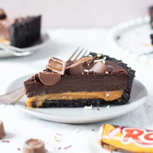A slice of no-bake Rolo tart on a plate with a fork