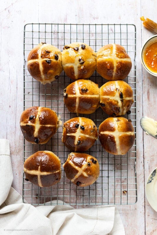 A selection of hot cross buns on a cooling rack