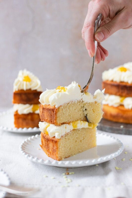 A fork cutting into a slice of Lemon Celebration Cake