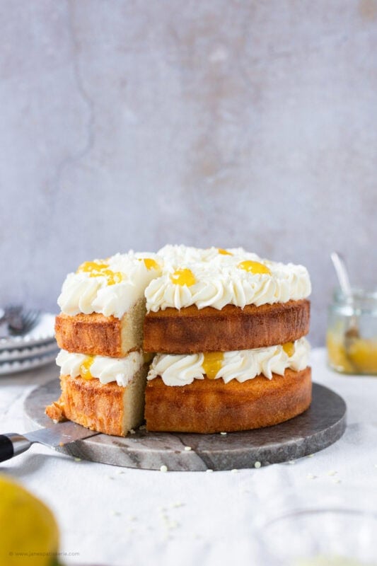 A slice cut into a whole Lemon Celebration Cake