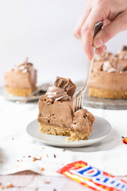 A fork cutting into a slice of No-bake Daim Cheesecake