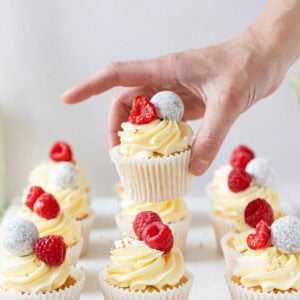 A hand holding a Prosecco Cupcake above the batch