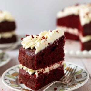 A slice of Red velvet cake on a plate with a fork