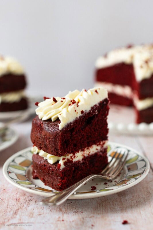 A slice of Red velvet cake on a plate with a fork