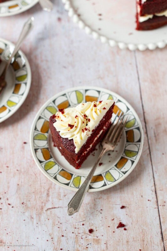 A slice of Red velvet cake on a plate with a fork
